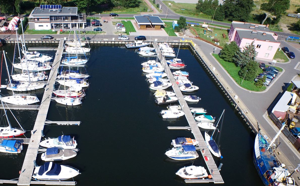 Darłowska Marina z pomostami i zacumowanymi jachtami, przy niej obiekt Baltic Resort Marina