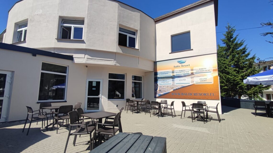 Budynek ośrodka Baltic Resort z tarasem, stolikami i parasolami