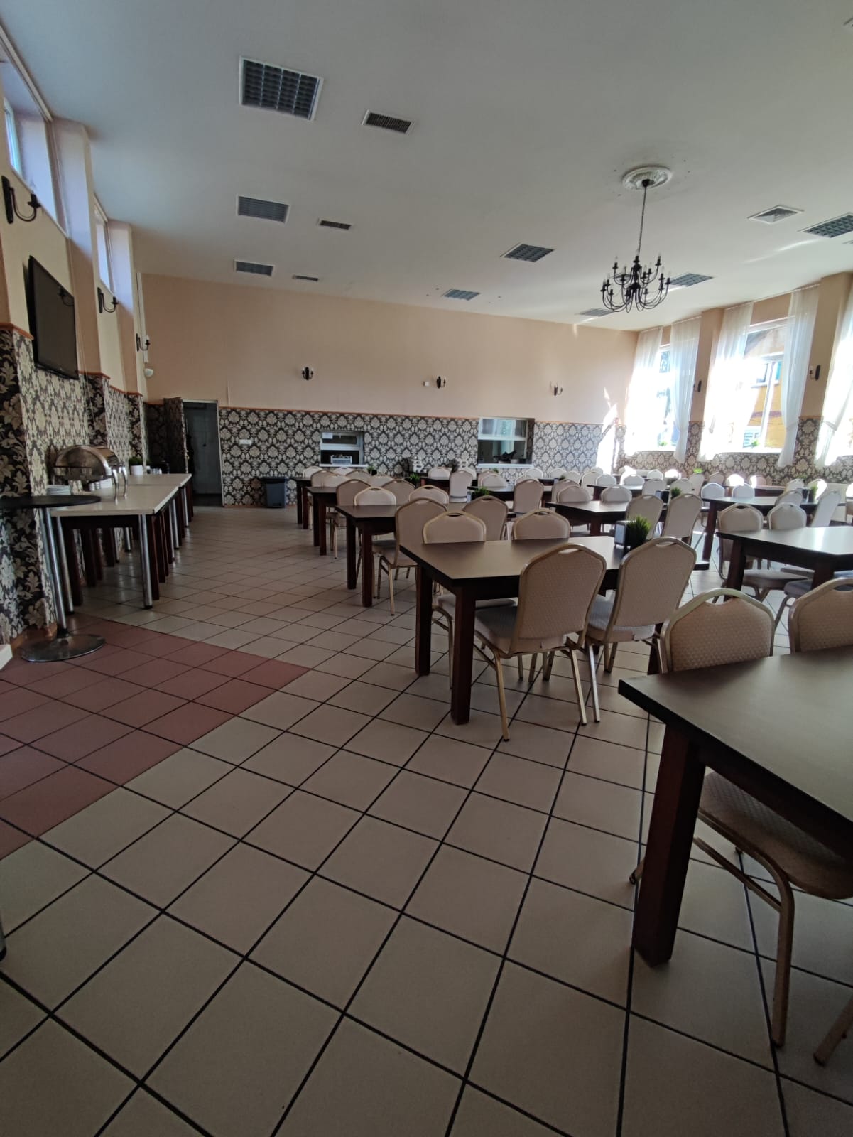 Przestronna jadalnia ośrodka ze stołami i podgrzewaczem bufetowym