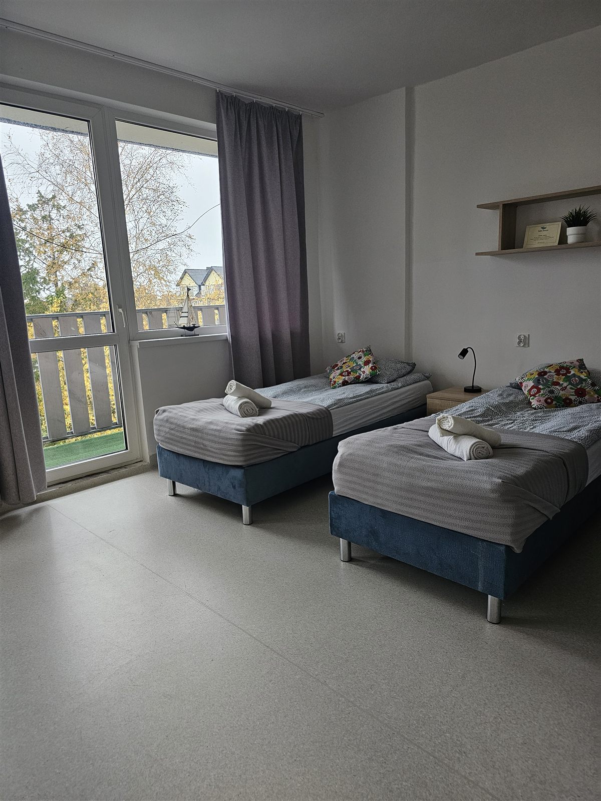 Pokój dwuosobowy w Baltic Resort z dwoma łóżkami, ręcznikami na pościeli i wyjściem na balkon